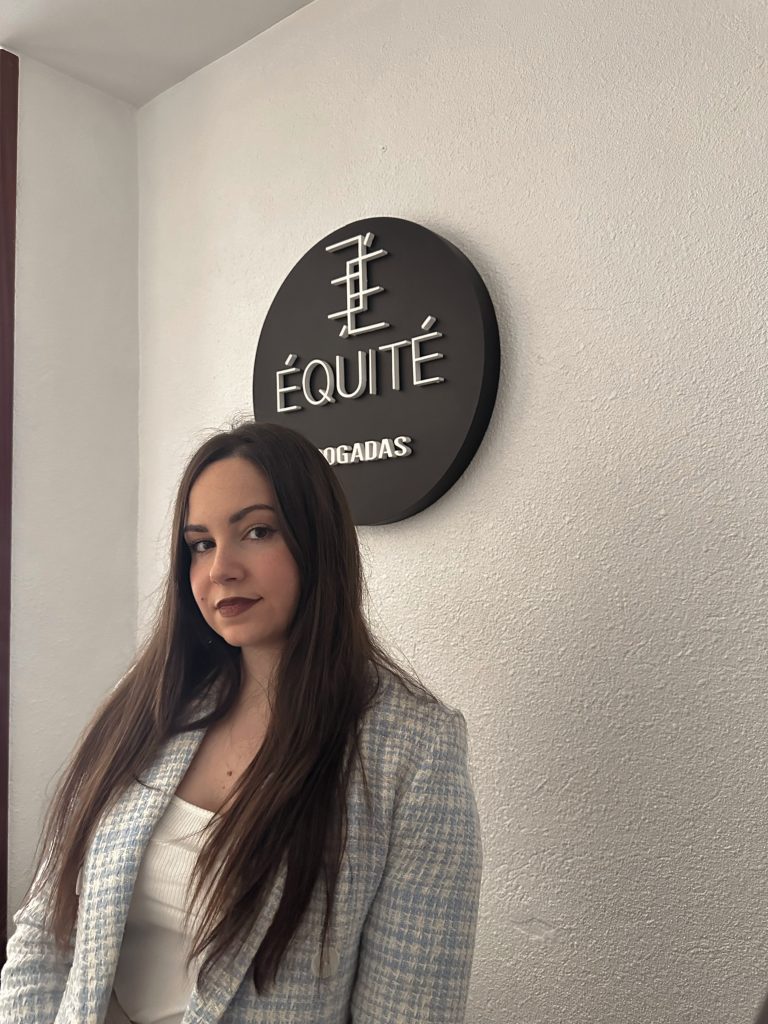 Una mujer está parada frente al un logo